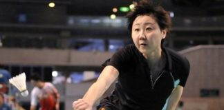 Zhou Mi of Hong Kong reaches for a return against Adriyanti Firdasari of Indonesia