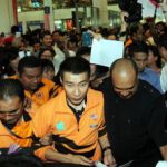 Chong Wei being escorted out upon his arrival at KLIA
