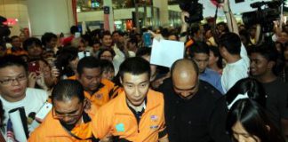 Chong Wei being escorted out upon his arrival at KLIA