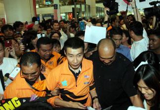 Chong Wei being escorted out upon his arrival at KLIA