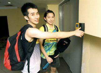 National shuttlers Chong Wei Feng (left) and Ho Yen Mei using the thumb print access system before entering Stadium Juara for training.