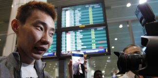 Lee Chong Wei, on arrival at the Kuala Lumpur International Airport, showing photographers a picture of him and Andrew Nari, the chief steward on MH370 which has disappeared. Chong Wei had met Nari on a previous flight.