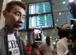 Lee Chong Wei, on arrival at the Kuala Lumpur International Airport, showing photographers a picture of him and Andrew Nari, the chief steward on MH370 which has disappeared. Chong Wei had met Nari on a previous flight.
