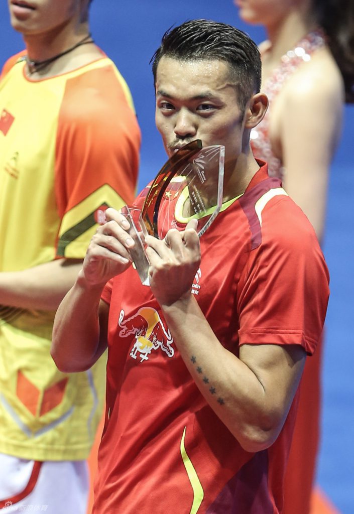 Lin Dan kisses his fifth China Masters badminton trophy