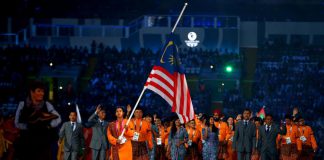 Flag bearer and Cyclist Fatehah Mustapa of Malaysia flies the flag at half mast during the Opening Ceremony for the Glasgow 2014 Commonwealth Games at Celtic Park on July 23, 2014 in Glasgow, Scotland. Quinn Rooney/Getty Images