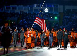 Flag bearer and Cyclist Fatehah Mustapa of Malaysia flies the flag at half mast during the Opening Ceremony for the Glasgow 2014 Commonwealth Games at Celtic Park on July 23, 2014 in Glasgow, Scotland. Quinn Rooney/Getty Images