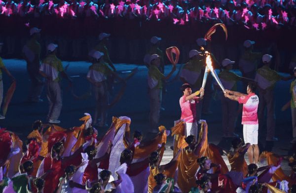 Lin Dan passes torch to a female Chinese short track speed skater Zhou Yang.