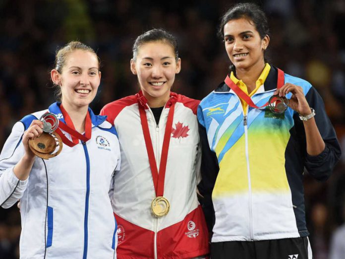 Canada's Michelle Li, gold medallist, is flanked by Scotland's Kirsty Gilmour, left, silver medallist, and India's PV Sindhu, right, bronze medallist, after the women's singles badminton final at the Commonwealth Games in Glasgow, Scotland on Sunday, August 3, 2014.
