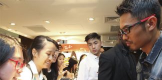 Wearing a slick pair of eyeglasses, Lin Dan signs autographs for his fans