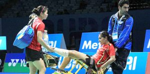 Leg injury: Indonesian women’s doubles shuttler Nitya Krishinda Maheswari (center) is carried off court in a wheelchair by an official helped by her playing partner Greysia Polii (left) during the match against Japan’s Reika Kakiiwa and Miyuki Maeda in the BWF Super Series Finals 2014 in Dubai, United Arab Emirates, earlier this month. They withdrew from the third game after Nitya sustained an injury to her left foot. Badmintonindonesia.org