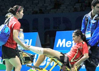 Leg injury: Indonesian women’s doubles shuttler Nitya Krishinda Maheswari (center) is carried off court in a wheelchair by an official helped by her playing partner Greysia Polii (left) during the match against Japan’s Reika Kakiiwa and Miyuki Maeda in the BWF Super Series Finals 2014 in Dubai, United Arab Emirates, earlier this month. They withdrew from the third game after Nitya sustained an injury to her left foot. Badmintonindonesia.org