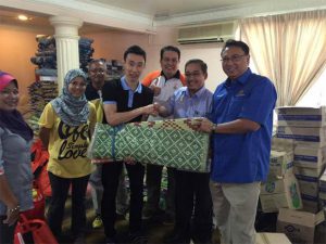 Lee Chong Wei hands over his donations to the flood relief officer (Photo: Lee Chong Wei's FB)