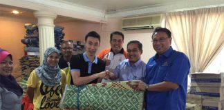 Lee Chong Wei hands over his donations to the flood relief officer (Photo: Lee Chong Wei's FB)