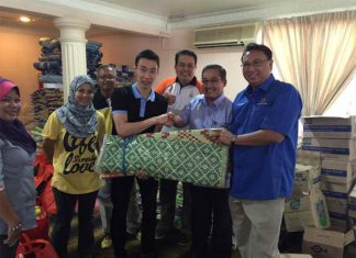 Lee Chong Wei hands over his donations to the flood relief officer (Photo: Lee Chong Wei's FB)