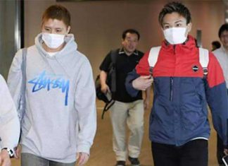 Kento Momota (r) and Kenichi Tago arrive at Narita airport Thursday morning.