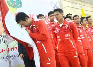 Indonesian Thomas Cup team captain Hendra Setiawan kisses Indonesia's national flag before departing to China for the 2016 Thomas & Uber Cup finals. ( Antara/Prasetyo Utomo)