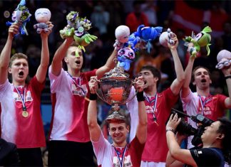 Hans-Kristian Vittinghus (C) of Denmark holds the Thomas Cup trophy between his teammates during the awards ceremony. (photo: AFP)