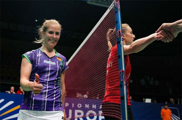 Laura Sarosi (in red) shows ultimate sportsmanship by borrowing Karin Schnaase her badminton shoes.