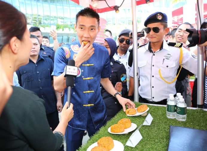 Lee Chong Wei tastes a piece of 'Moon Cake' during the mid-autumn festival. (photo: Sinchew)