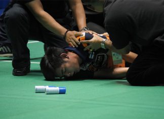 Pannawit Thongnuam receives medical attention after collapsing on court.
