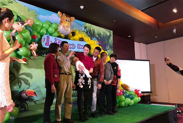 Lin Dan, Xie Xingfang, and their baby take picture with family and friends.