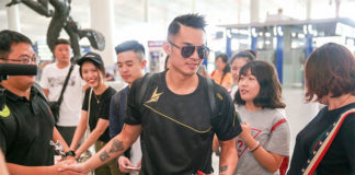 Lin Dan takes pictures with his fans.
