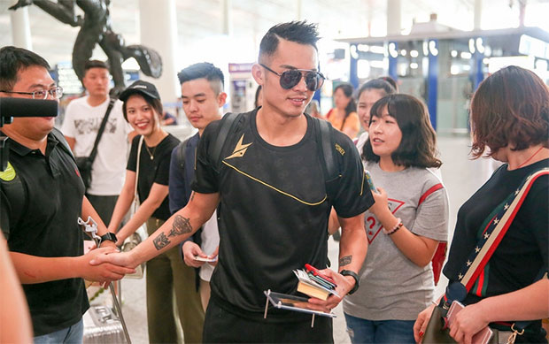 Lin Dan takes pictures with his fans.