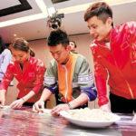 Huang Yaqiong, Zheng Siwei and Shi Yuqi make Chinese dumpling. (photo: AFP)