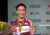 Kento Momota holds the German Open trophy after beating teammate Kenta Nishimoto in the final.