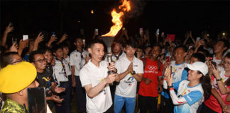 Lee Chong Wei receives Olympic flame from Chan Peng Soon during torch relay. (photo: Penang Olympic Carnival)