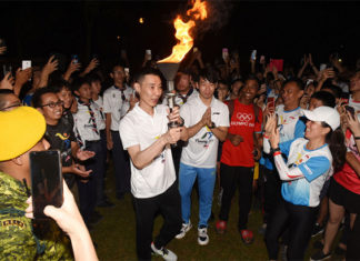 Lee Chong Wei receives Olympic flame from Chan Peng Soon during torch relay. (photo: Penang Olympic Carnival)