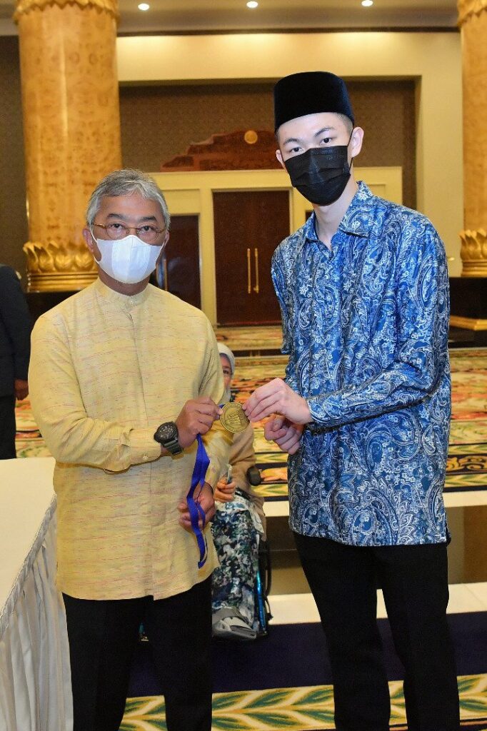 Lee Zii Jia shows the All England gold medal to the King of Malaysia. (photo: Bernama)