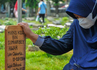 The wife of the late Markis Kido, Richasari Pawestri, prays after her husband's funeral at the Kebon Nanas TPU, East Jakarta. (photo: ANTARA FOTO/ Fakhri Hermansyah/aww)