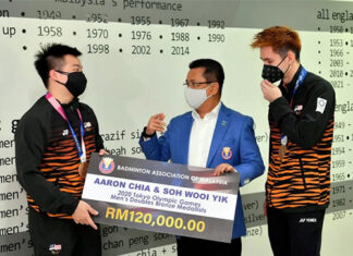 Aaron Chia/Soh Wooi Yik receive a check of RM120,000 from the President of BAM, Tan Sri Mohamad Norza Zakaria. (photo: Bernama)