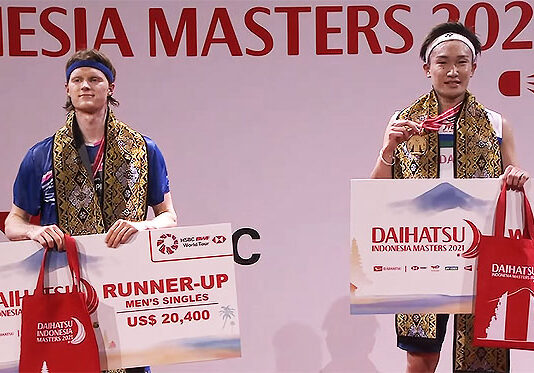 Kento Momota (R) and Anders Antonsen pose for pictures at the 2021 Indonesia Masters award ceremony.