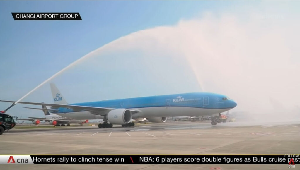 Loh Kean Yew's flight receives a water cannon salute. (source: Screenshot CNA YouTube)