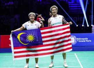 Chen Tang Jie and Toh Ee Wei proudly holding the Malaysian flag after winning the gold medal at the 2025 Badminton World Championships. (Photo: AFP)