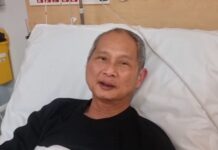 Malaysian badminton coach Wong Tat Meng in a hospital bed as he speaks to fans in a recovery video shared by Roketto Badminton. (Photo: Roketto Badminton)