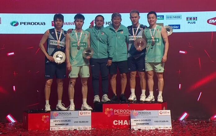Aaron Chia and Soh Wooi Yik pose alongside Man Wei Chong and Tee Kai Wun with their coaches after an all-Malaysian final at the 2025 Malaysia Masters awards ceremony. (Photo: BWF)