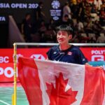 Victor Lai celebrates with a Canadian flag after defeating Jonatan Christie to win the Indonesia Open badminton men’s singles title in Jakarta. (Photo: AFP)