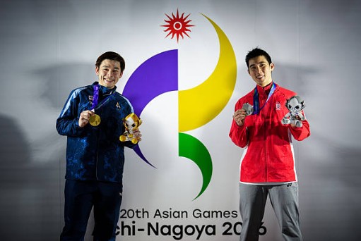 Kunlavut Vitidsarn (L) and Loh Kean Yew pose in front of the Aichi-Nagoya 2026 Asian Games logo following the men’s singles badminton awards ceremony. (Photo: AFP)