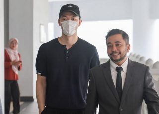 Lee Zii Jia arrives at the Kuala Lumpur High Court with his lawyer before mediation that led to a settlement with his family over LZJ Management. (Photo: Bernama)